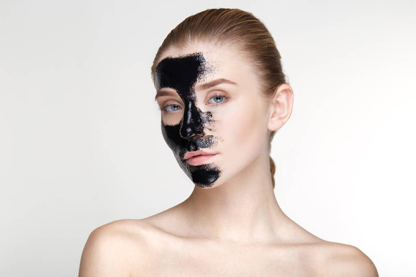 Retrato de belleza mujer cuidado de la piel salud máscara negra fondo blanco de cerca - Foto, imagen
