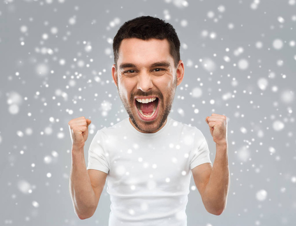 angry young man celebrating victory over snow - Foto, immagini