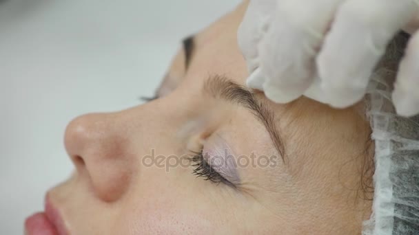 Young pretty woman getting cosmetic injection in the face like a part of the clinic treatment. Medicine, healthcare and beauty concept - Filmati, video