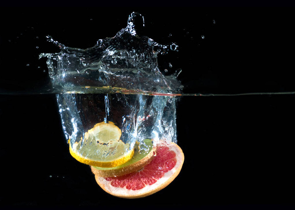 Tropical fruits fall underwater - Foto, afbeelding