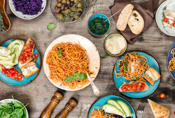 Italian pasta with tomato sauce with snacks on wooden table - Zdjęcie, obraz