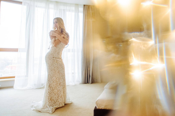 ランジェリーと白いドレスの美しい朝の花嫁 - 写真・画像