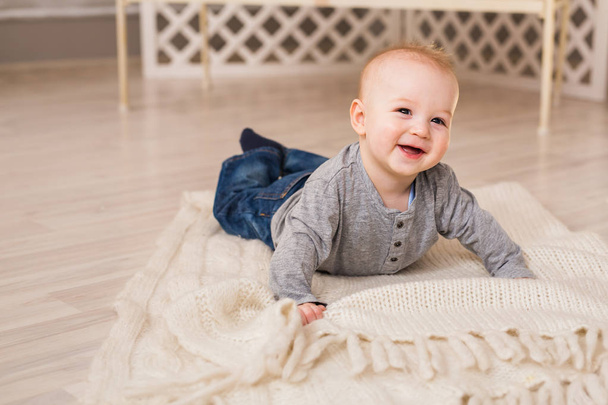 Adorable laughing baby boy in white sunny bedroom. Newborn child relaxing. Family morning at home. - Photo, Image
