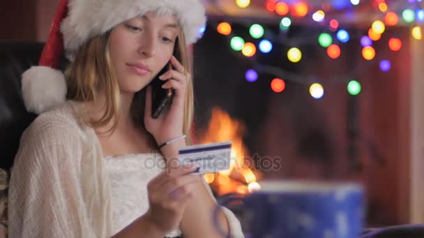 A woman calls in her order with a credit card using a smart phone - dolly - Materiał filmowy, wideo