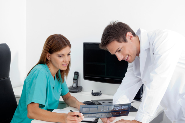 Dentist With Assistant Analyzing X-Ray Report - Foto, Imagem