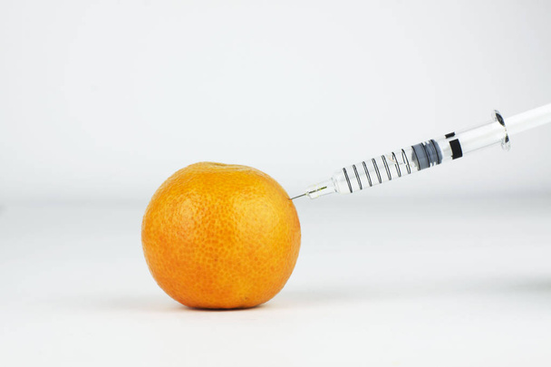 Syringe injecting an orange - Photo, Image