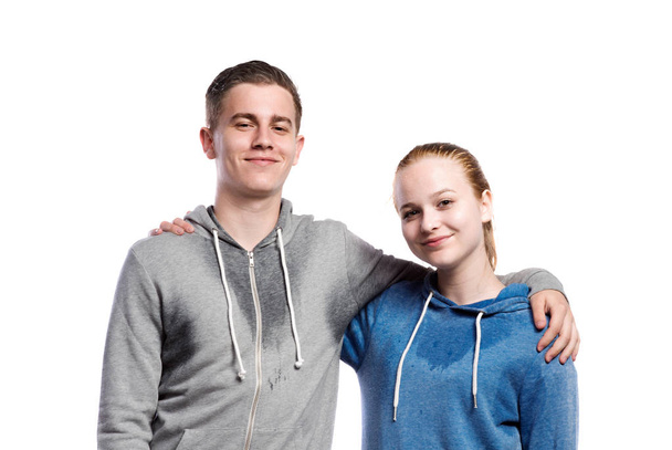 Teenage boy and girl in sweatshirts. Studio shot, isolated. - Foto, imagen