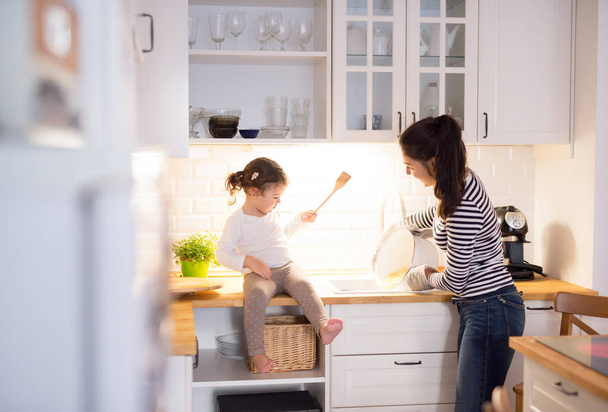 台所で一緒に調理中の彼女の娘と母 - 写真・画像