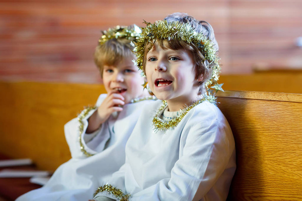 Due ragazzini come angeli della vigilia di Natale in chiesa
 - Foto, immagini