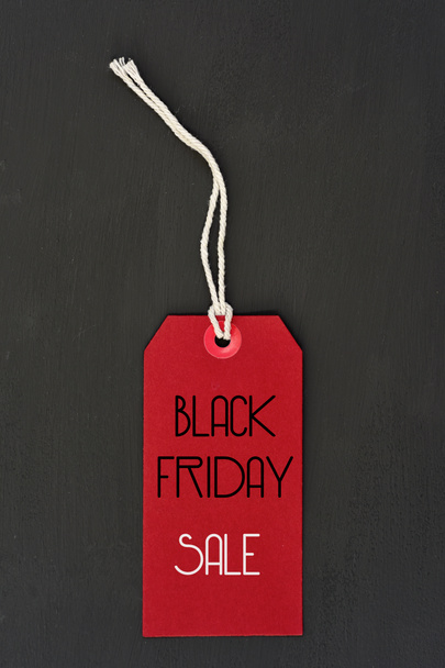 text black friday sale in a red paper label - Фото, изображение