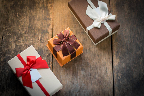 Three gift boxes on wooden background - Photo, Image
