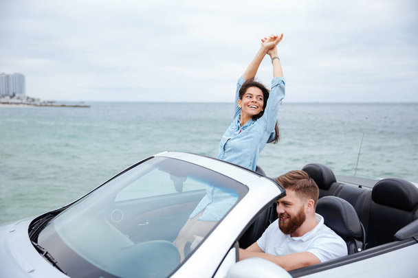 Young couple on road trip driving in convertible car - Foto, Bild