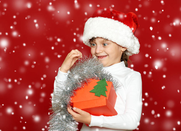 girl child portrait with gift box on red, christmas holiday concept - Valokuva, kuva
