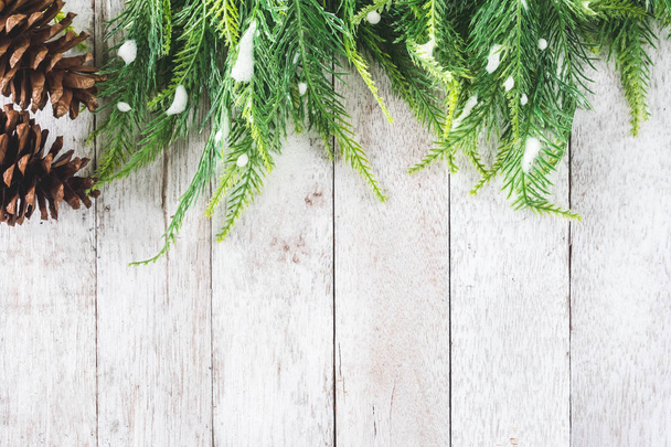 Bovenaanzicht van Fir tree met dennenappels op houten tafel, kerst decoratie achtergrond - Foto, afbeelding