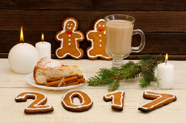 New Year's  concept. Christmas dinner: gingerbread, spruce branch, cappuccino with pie, candles - Photo, Image