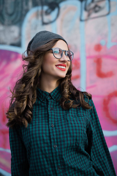 kudrnatá dívka s transparentní brýlemi s úsměvem - Fotografie, Obrázek