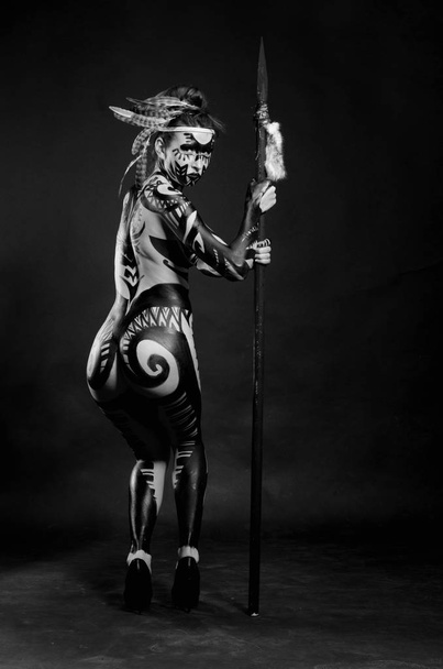 girl painted with black paint in the image of warrior women on a black background - Φωτογραφία, εικόνα