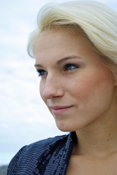 Face of a beautiful blond caucasian model girl in front of the sky - Fotó, kép