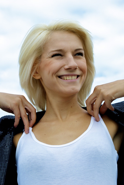 Beautiful blonde girl smiles in front of the sky - Φωτογραφία, εικόνα
