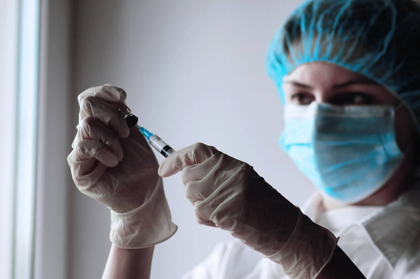health worker dials the vaccine into a syringe - Фото, изображение