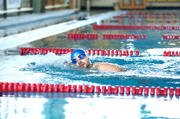 Young man swimming in pool - Фото, изображение