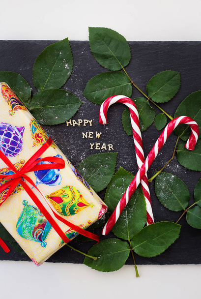 iscrizione di anno nuovo su una lavagna nera con regalo e caramelle rosse
 - Foto, immagini