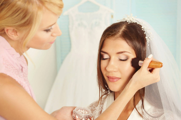 Wedding preparation. Professional makeup artist applying blush to bride - Photo, image