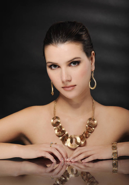 beautiful woman in golden jewelry - Фото, зображення