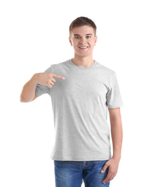 Knappe jongeman in lege grijs t-shirt op witte achtergrond - Foto, afbeelding