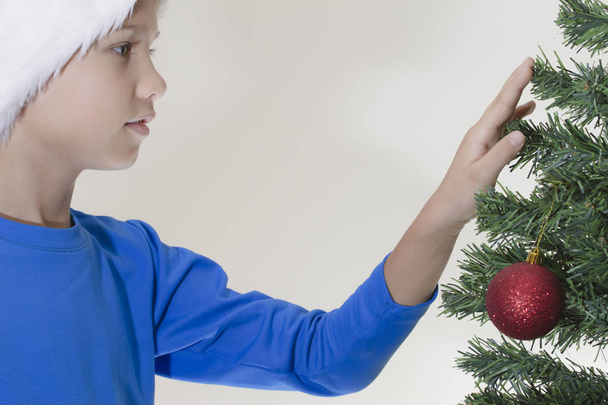Chlapec v Santa čepici u vánočního stromu - Fotografie, Obrázek