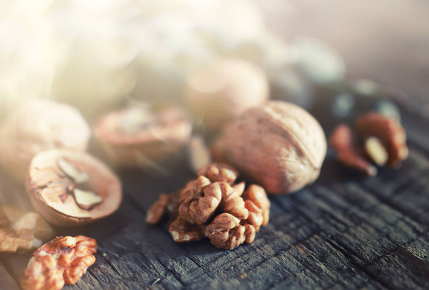 walnuts, whole and peeled wooden background - 写真・画像