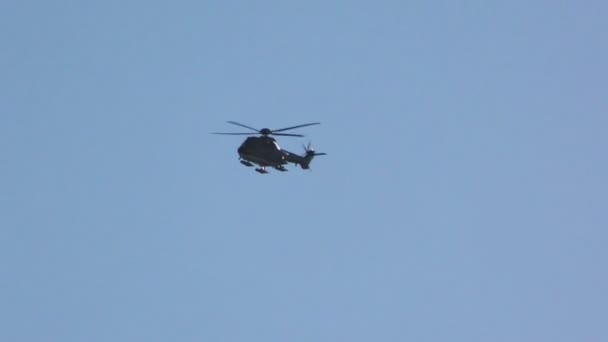 Musta helikopteri lentää sinistä taivasta vasten
 - Materiaali, video