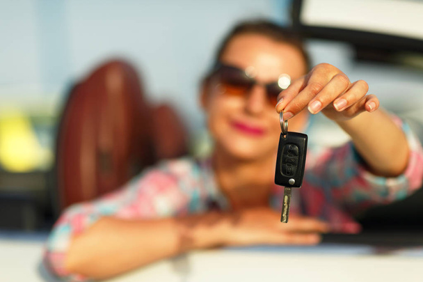 Woman sitting in a convertible car with the keys in hand - Foto, Imagen