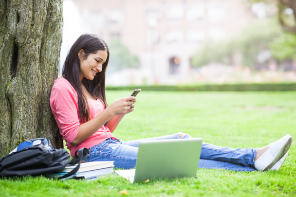 Hispanic college student texting - Foto, afbeelding