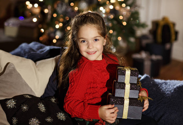 Very beautiful long-haired girl smiles and holding a gift in New - Foto, Imagen