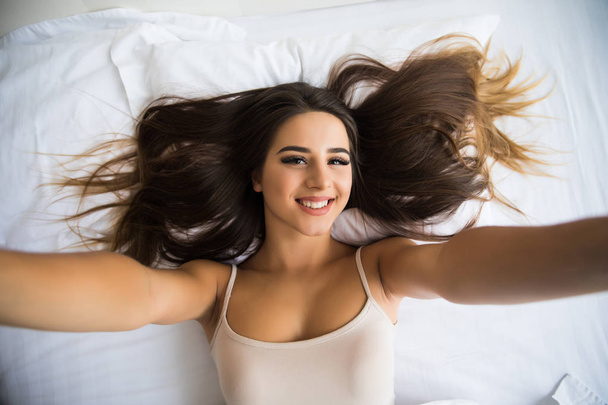 девушка делает селфи в постели
 - Фото, изображение