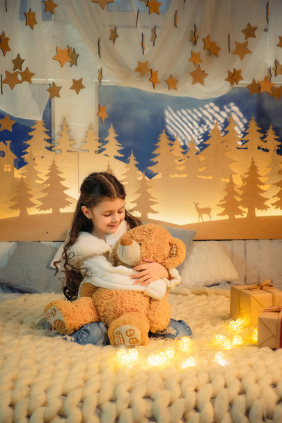 Child with teddy bear in Christmas atmosphere - Φωτογραφία, εικόνα