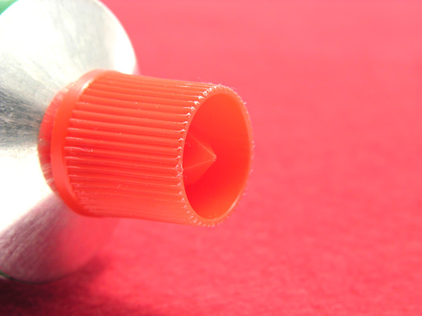 Un tube allongé avec un joint rouge sur u rouge
 - Photo, image