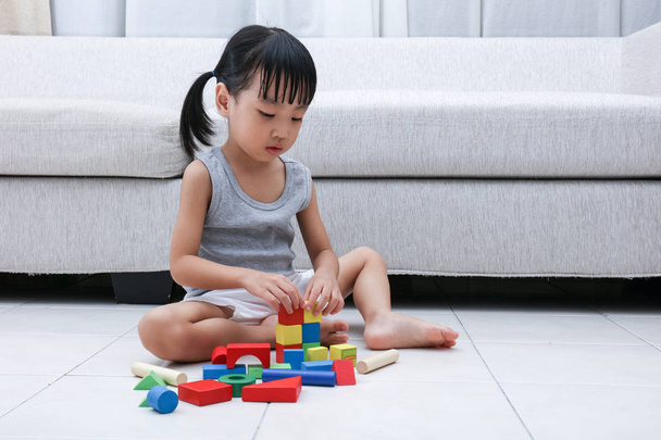 Asian Chinese little girl playing blocks on the floor - 写真・画像