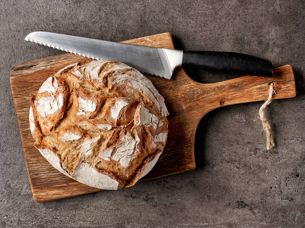 freshly baked bread and knife - Фото, зображення