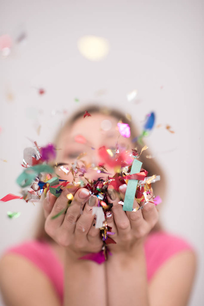 woman blowing confetti in the air - 写真・画像