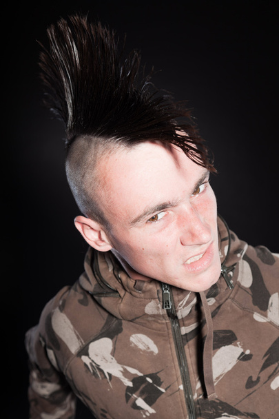 Punk man with mohawk haircut. Expressive face. Army camouflage jacket. Isolated on black background. Studio shot. - Fotoğraf, Görsel