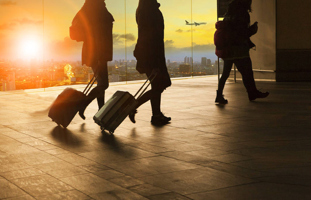 άνθρωποι και ταξιδεύουν περπάτημα αποσκευών στο αεροδρόμιο τερματικού κτίρ - Φωτογραφία, εικόνα