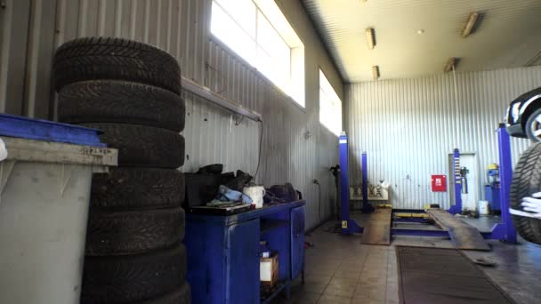 Homme empilant des pneus usés dans le garage. services de changement et de stockage de pneus
. - Séquence, vidéo