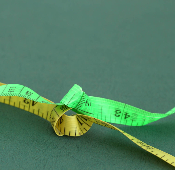 yellow and green tape measure on green background - Photo, Image