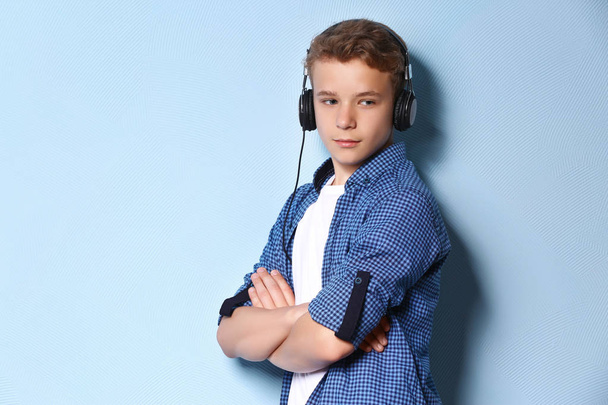 Boy listening music on light background - Фото, изображение
