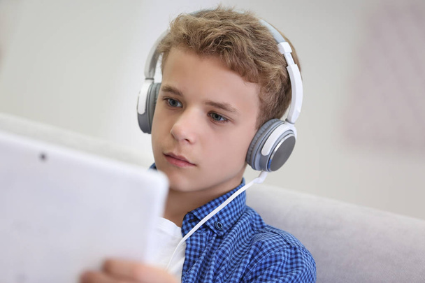 Boy listening music on sofa - Zdjęcie, obraz
