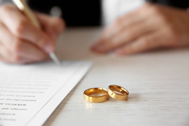 Golden wedding rings on table at notary office, closeup - Fotó, kép