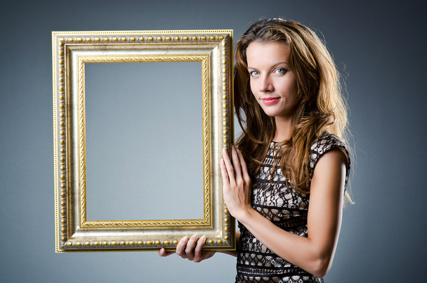 Young woman with picture frame on white - Zdjęcie, obraz