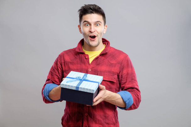 Happy young man with a gift - Φωτογραφία, εικόνα